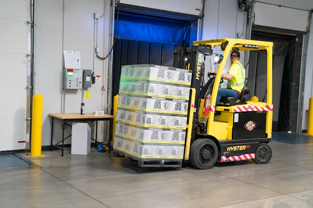 Forklift operator in warehouse moving pallets