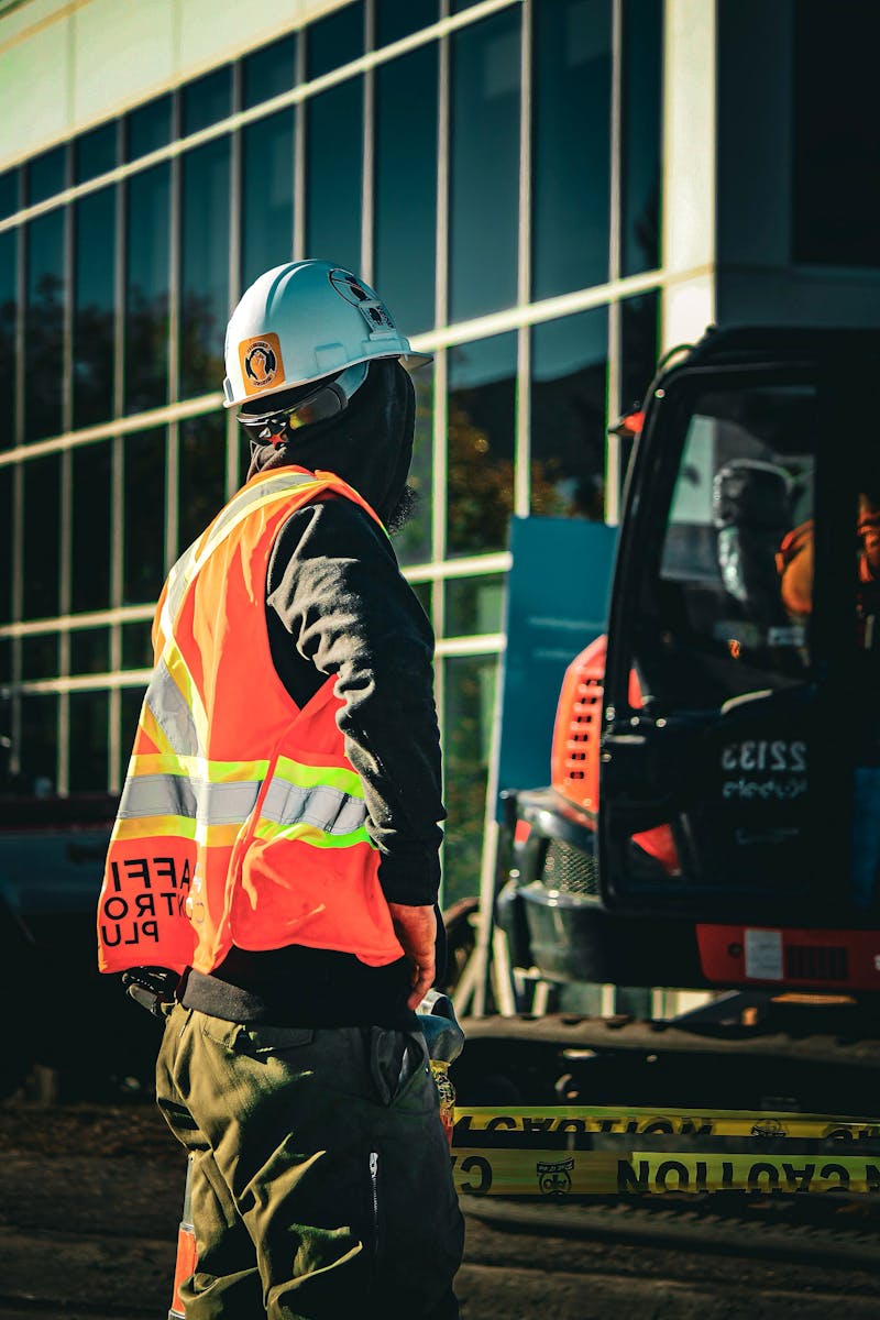 Traffic controller holding stop sign on road in hi-vis vest